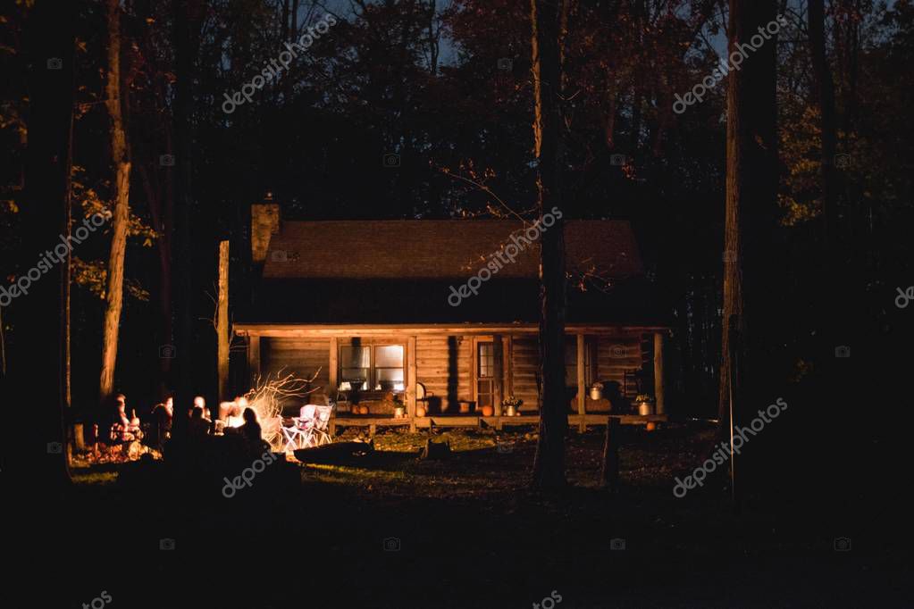 A beautiful silhouette shot of wooden cabin in the woods