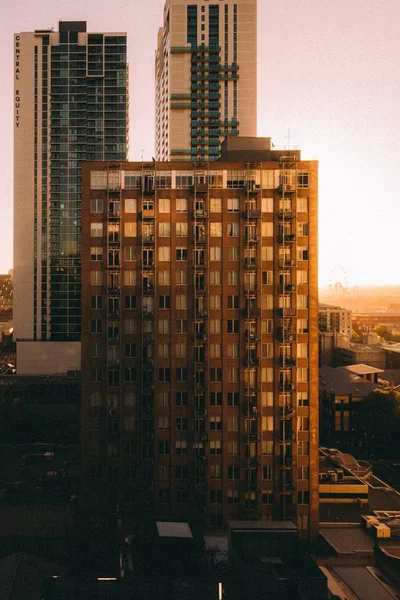 Edifício de apartamentos altos com um belo pôr do sol no fundo — Fotografia de Stock