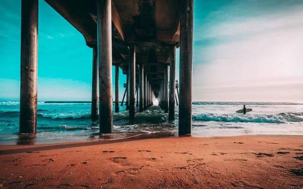 Debaixo da área do cais longo de madeira na costa de um mar bonito — Fotografia de Stock