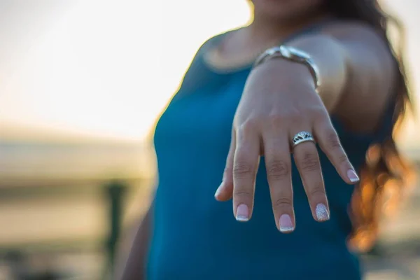 Закройте женскую руку, показывая обручальное кольцо на закате — стоковое фото