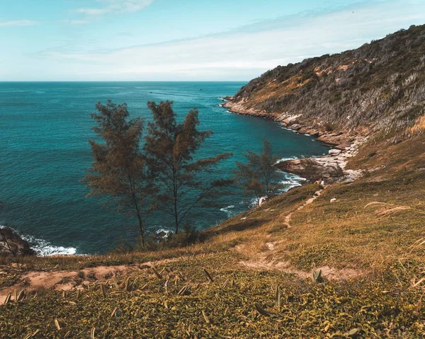 急な岩の丘と曇りの空と海の海岸の美しいショット — ストック写真