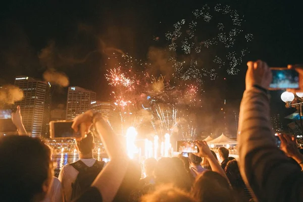 Grupo de pessoas desfrutando de fogos de artifício brilhantes em um festival — Fotografia de Stock