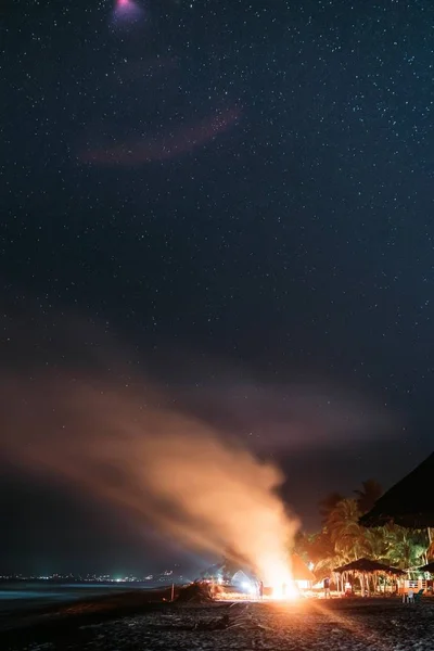 Hermoso disparo de una fogata con humo subiendo y un increíble cielo nocturno estrellado — Foto de Stock