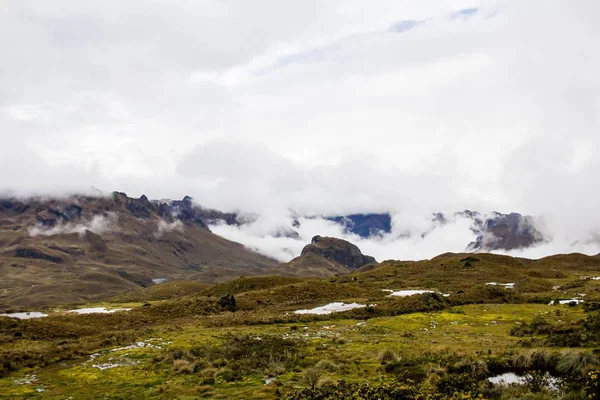 Campo bonito com incríveis montanhas rochosas e colinas no fundo e incrível céu nublado — Fotografia de Stock