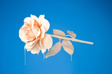 Beautiful isolated rose entirely covered in creamy oil paint with an aesthetic blue background clipart