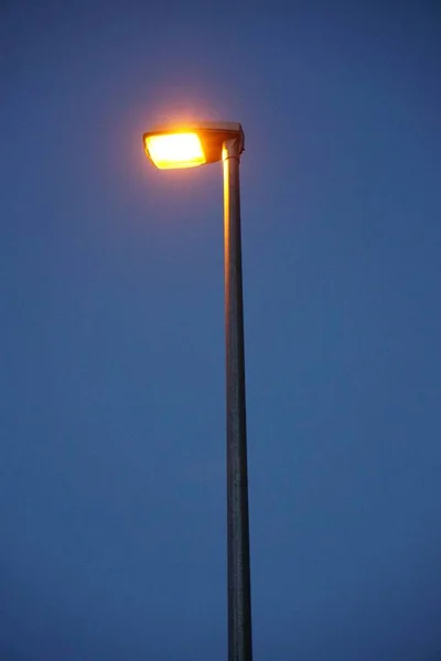 暗い青の背景に金属照明街路灯の垂直ショット — ストック写真