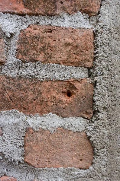 Zbliżenie pionowego ujęcia wywietrzonej ściany z cegły-nieczysty tle — Zdjęcie stockowe