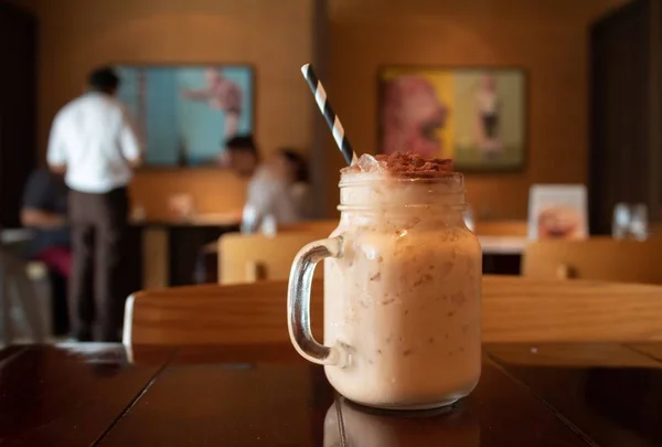 Closeup of a tasty Thai milk tea on a table in a cafe with a blurred background — Stock Photo, Image