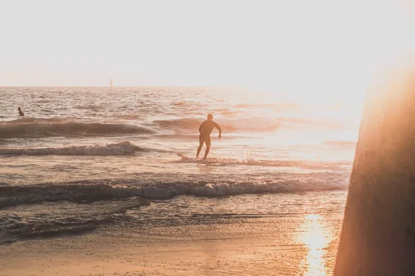 A surfer running on the beach