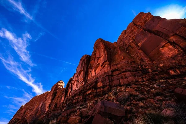 Colpo basso di una collina rocciosa e una grande scogliera desertica con cielo blu sullo sfondo — Foto Stock