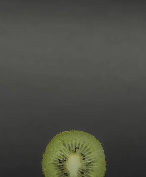 Corte o único kiwi suculento em um fundo preto — Fotografia de Stock