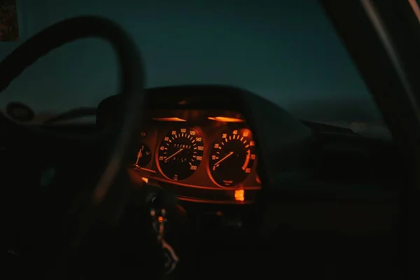 Painel do carro iluminado em vermelho com um volante à noite — Fotografia de Stock