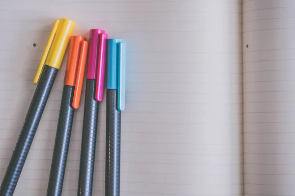 Closeup shot színes markerek egy nyitott tankönyv — Stock Fotó