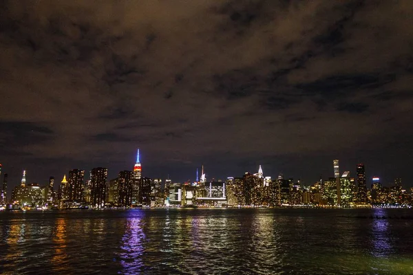 Manhattan at night shot from afar with river reflection — Stock Photo, Image