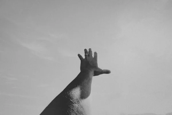 Zwart-wit monochrome opname van de linkerhand van een persoon op een breed oppervlak — Stockfoto