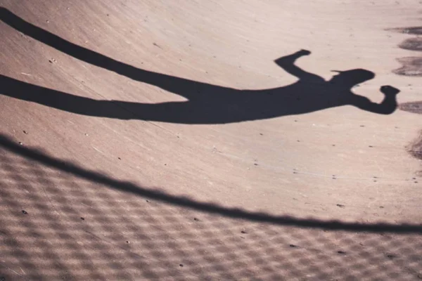 Silhouette di un pattinatore di pattinaggio maschile in un parco — Foto Stock