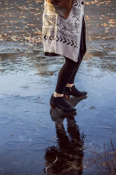 Ноги женщины в хлопковом пальто, скользящей по льду — стоковое фото