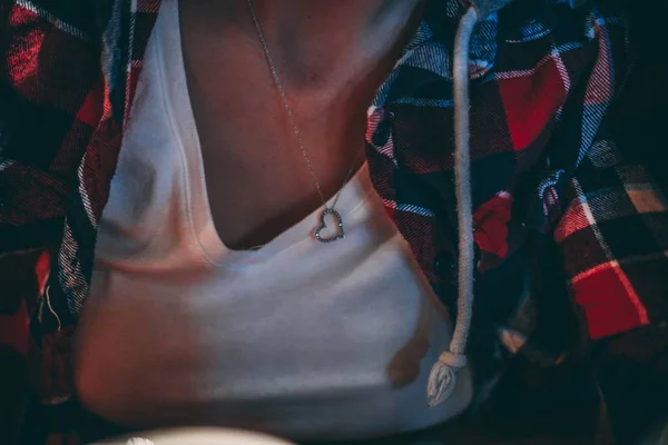 Nahaufnahme einer Frau mit weißem Oberteil und herzförmiger Halskette — Stockfoto