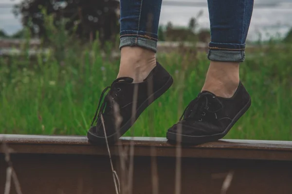 Extreme close seup shot of a person wearing black low-top sneakers with laces — стоковое фото