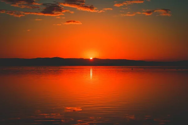Hermosa vista panorámica de la puesta de sol roja sobre un lago — Foto de Stock