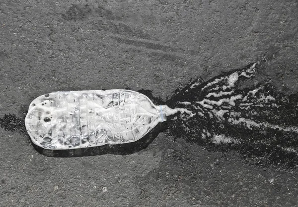 Tiro de una botella derramada en la superficie negra —  Fotos de Stock