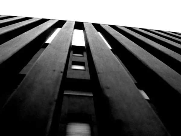 Disparo de ángulo bajo de una pared cerca de un edificio en blanco y negro — Foto de Stock