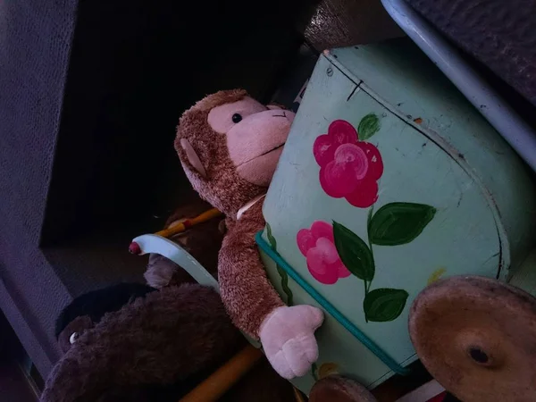 Zbliżenie strzał z nadziewane brązowy zabawka małpa w turkusowy niebieski zabawka wózek z kwiatowymi nadrukami — Zdjęcie stockowe