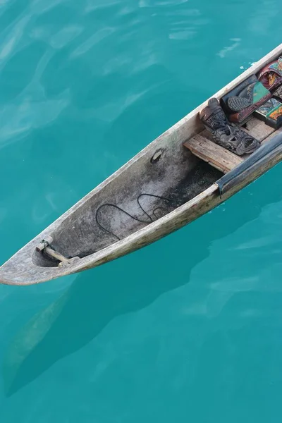 Colpo verticale di una barca di canoa di legno con una maschera tribale su di esso — Foto Stock