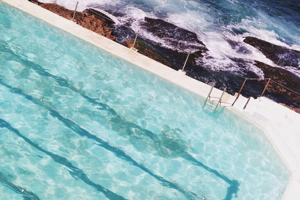 Beau plan d'une piscine près des rochers et de la mer — Photo