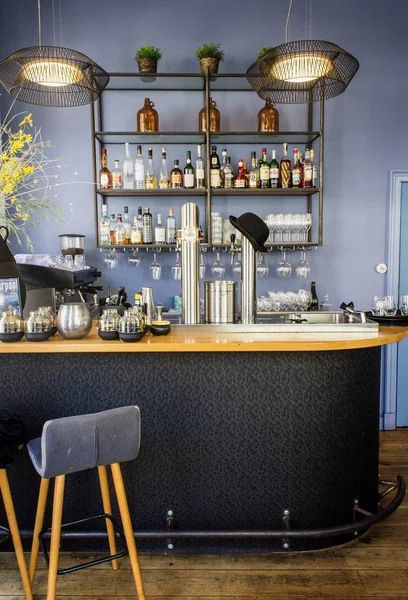 Tiro vertical de um bar com garrafas de bebida diferentes em uma prateleira — Fotografia de Stock