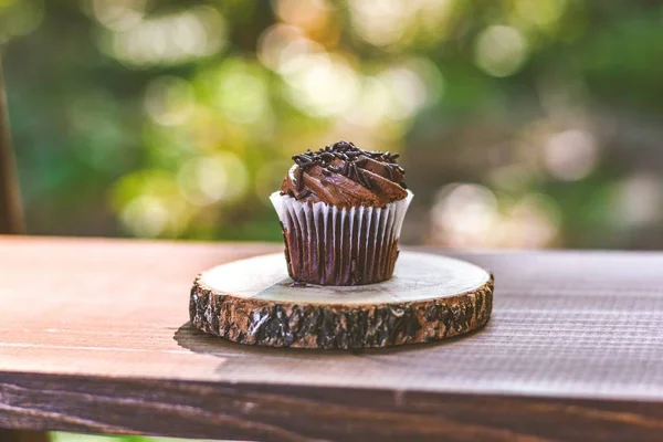 Gros plan sélectif d'un cupcake au chocolat sur une planche ronde en bois — Photo