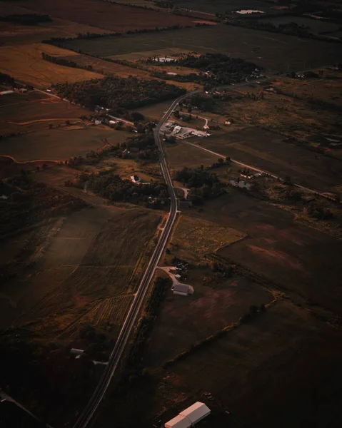 Colpo aereo verticale di una stretta strada di campagna con campo agricolo su entrambi i lati — Foto Stock