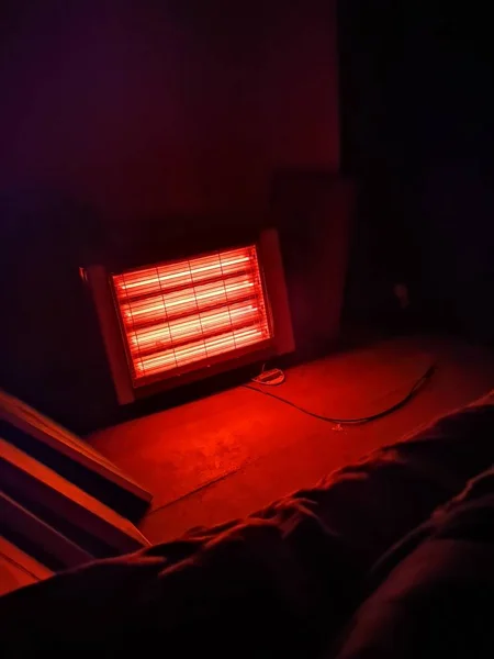 Vue verticale d'un radiateur électrique éclairant dans une pièce sombre — Photo
