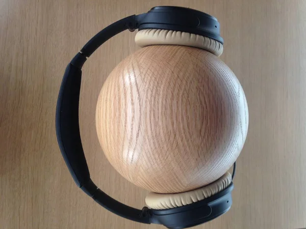 Closeup shot of black headphones on a wooden ball — Stock Photo, Image