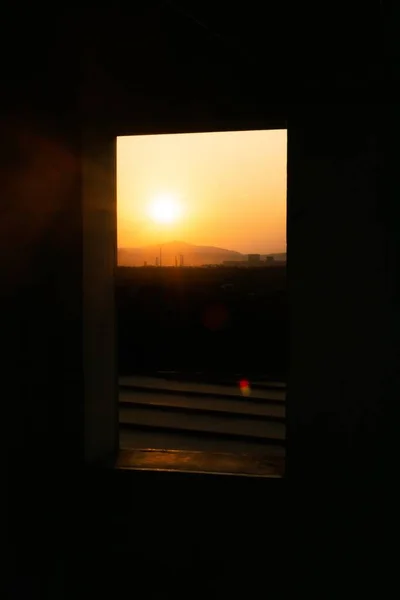 Κάθετη βολή από μια ωραία θέα στο ηλιοβασίλεμα μέσα από ένα παράθυρο — Φωτογραφία Αρχείου