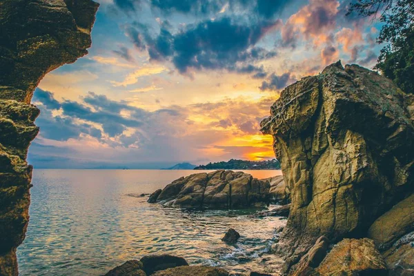 A beautiful wide shot of rock formation by the sea during golden hour