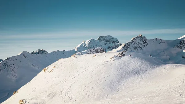 Szeroki Strzał Gór Pokrytych Śniegiem Pod Jasnym Błękitnym Niebem Połową — Zdjęcie stockowe