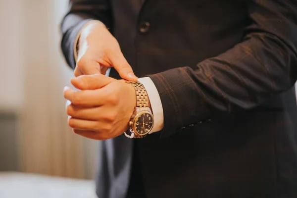 Primer plano de la mano de un hombre que se pone su reloj clásico antes de que comience la ceremonia de boda — Foto de Stock