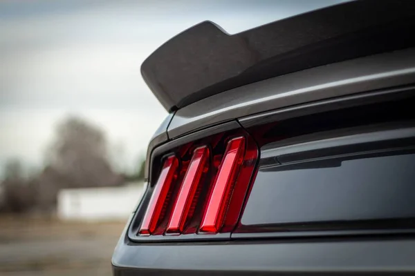 Selectieve close-up shot van rode achterlicht van een grijze auto — Stockfoto
