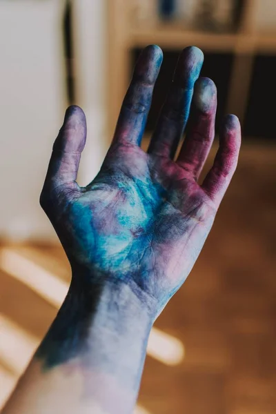 Selective closeup shot of a person's palm in blue and pink paint — Stock Photo, Image