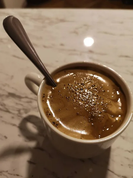 Крупним планом знімок традиційно приготованої кави в білій чашці з ложкою в ньому — стокове фото