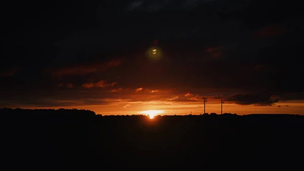 Amplo tiro das silhuetas de colinas no campo ao pôr do sol — Fotografia de Stock