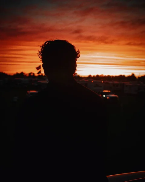 Silhueta de uma pessoa olhando para o belo céu vermelho ao pôr do sol — Fotografia de Stock