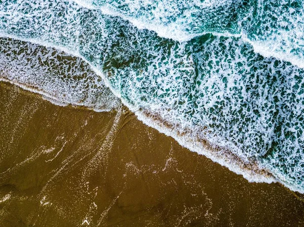 Breed shot van blauwe zee golven op een zanderige kust — Stockfoto