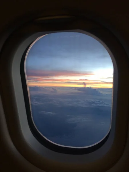 Pionowe Okno Samolot Strzał Widokiem Niebiesko Żółte Niebo Chmur — Zdjęcie stockowe