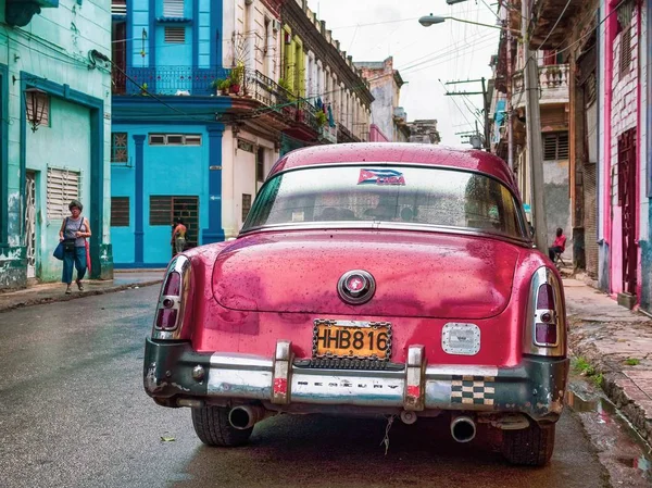 Närbild skott av en Vintage rosa bil parkerad på en gata nära färgglada byggnader — Stockfoto