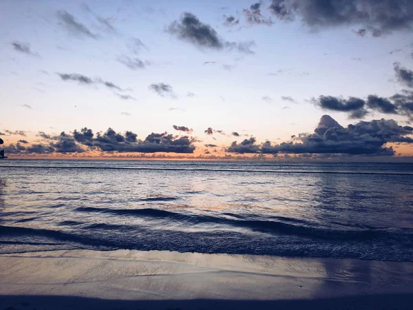 Bela paisagem larga tiro do mar sob um céu com nuvens cinzas durante o pôr do sol — Fotografia de Stock