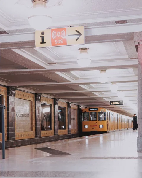 Pionowe ujęcie żółtego pociągu zbliżającego się do stacji — Zdjęcie stockowe