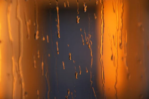 Cool background of water drops on glass and orange blurred background