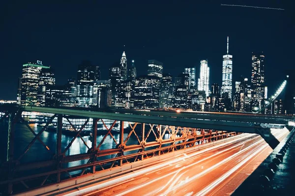 夜のニューヨークの道路の上の高層ビルやブルックリン橋の広いショット — ストック写真